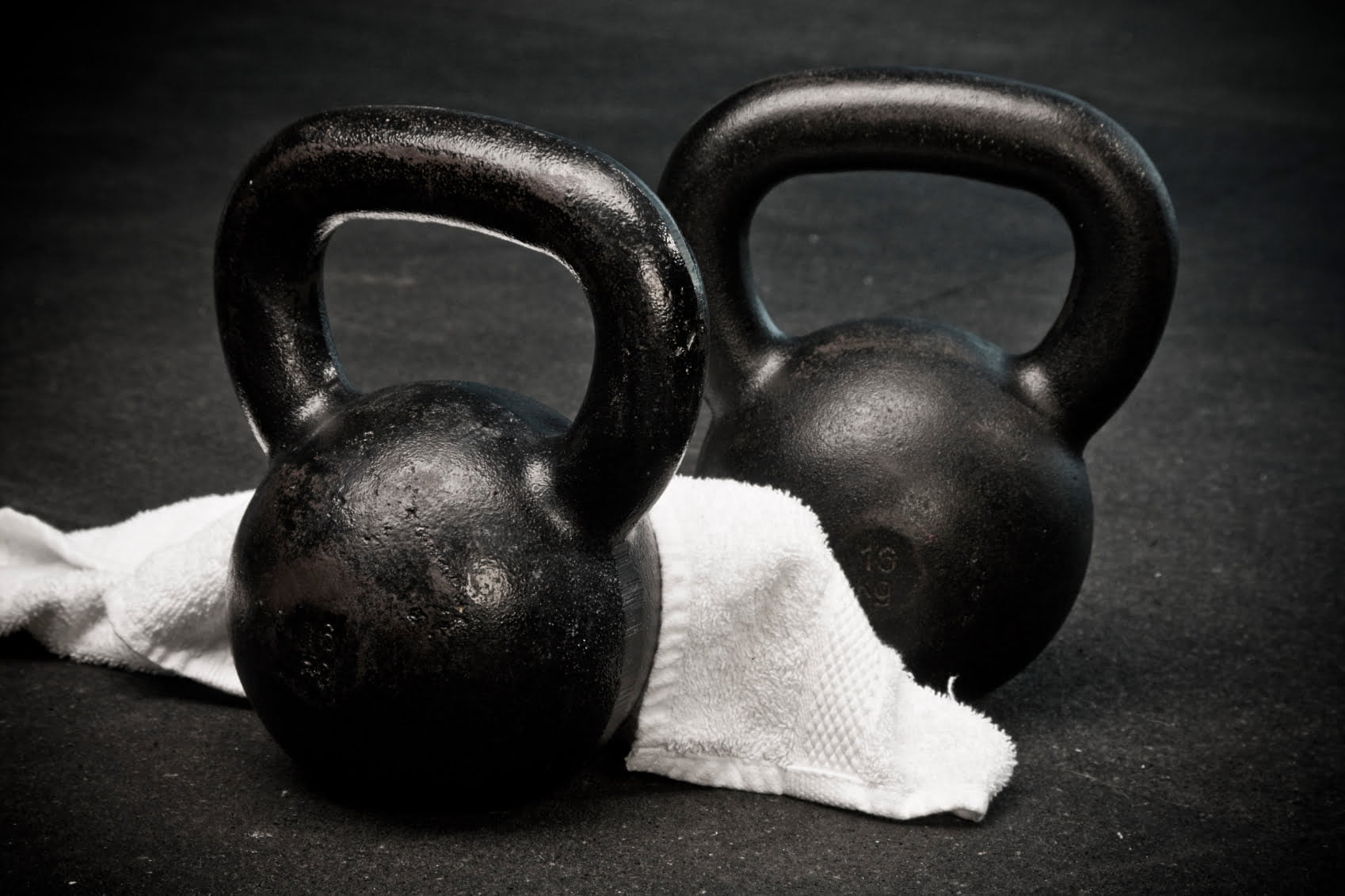 kettlebells-with-towel-on-gym-floor